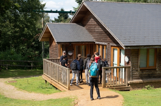 children arriving to a log cabin residential trip in surrey